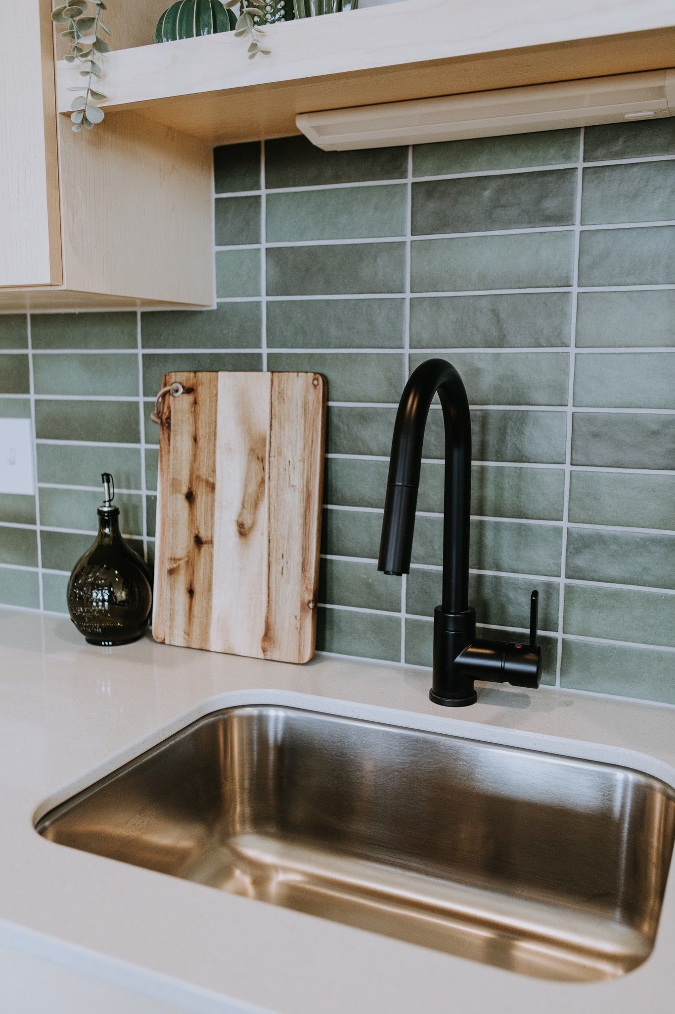 green tile kitchen backsplash with modern sink fixture